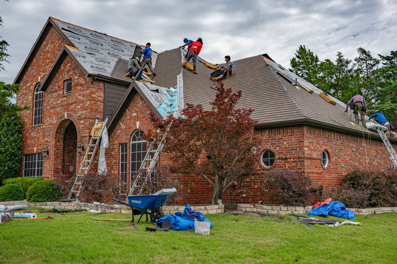 A roofer installing new shingles during a roof replacement.